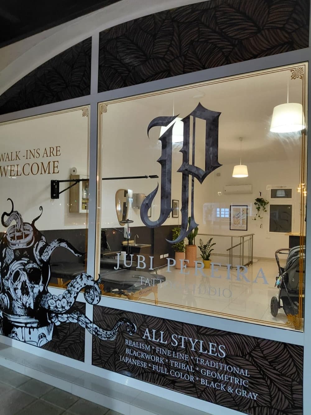 The studio window with a large JP monogram and a skull illustration.